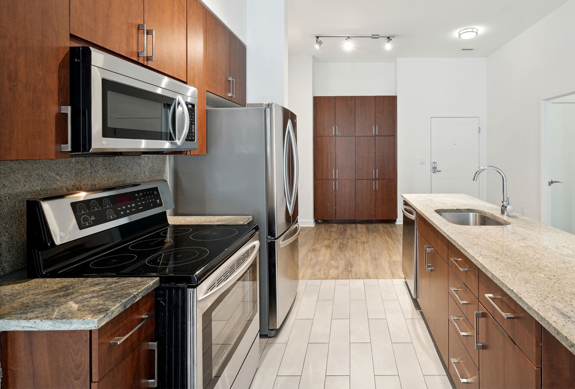 Kitchen with stainless appliances, island with sink, and custom cabinetry